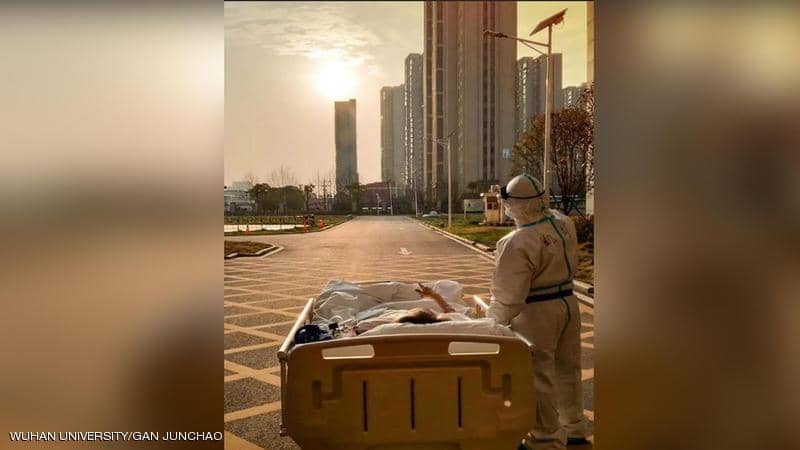 الطبيب ليو والمريض الثمانيني يشيران إلى قرص الشمس في ووهان